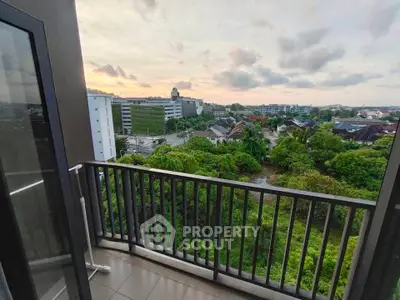 Stunning balcony view overlooking lush greenery and cityscape at sunset, perfect for relaxation and enjoying nature.