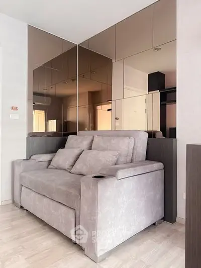 Modern living room with stylish sofa and mirrored wall panels