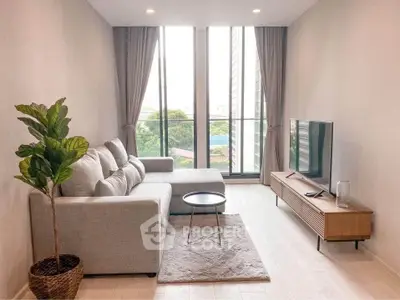 Modern living room with large windows, cozy sofa, and stylish decor in a high-rise apartment.