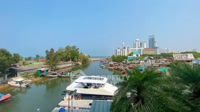 Scenic waterfront view with modern buildings and boats, ideal for luxury real estate investment.