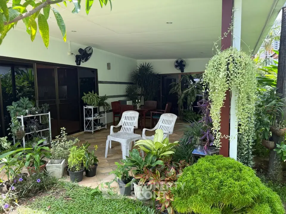 Charming garden patio with lush greenery and cozy seating area, perfect for relaxation and outdoor gatherings.