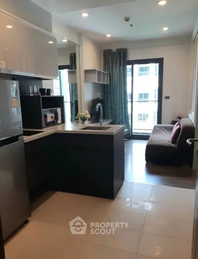 Modern open-layout kitchen with sleek appliances and cozy living area, perfect for urban living.