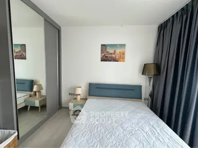 Modern bedroom with stylish decor and large mirrored wardrobe in a contemporary apartment.