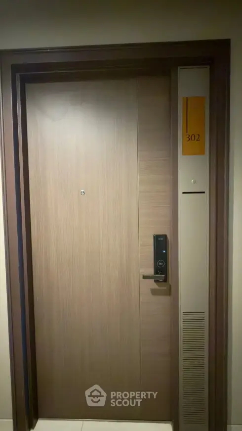 Modern apartment door with electronic lock and room number 302, showcasing secure entry features.