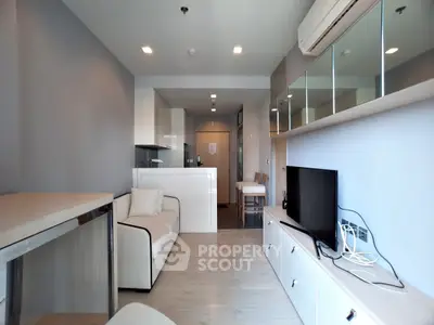 Modern living room with sleek furniture and open kitchen layout in a stylish apartment.