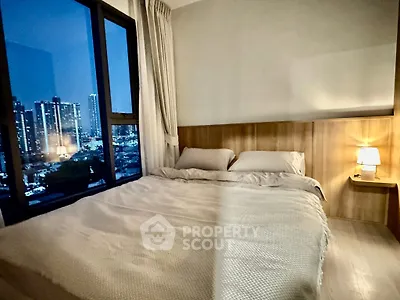 Cozy bedroom with city view, featuring a large window and elegant lighting, perfect for urban living.