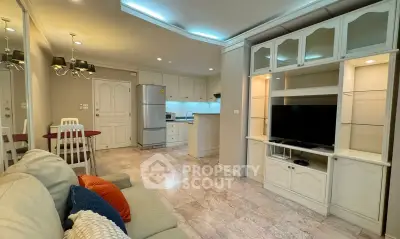 Spacious living room with elegant built-in entertainment center and modern kitchen in open layout.