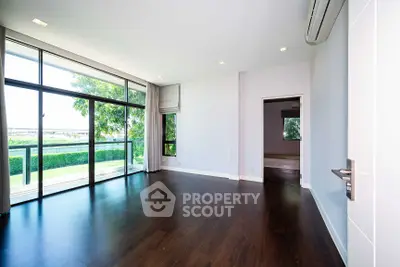 Spacious modern living room with large windows and wooden flooring