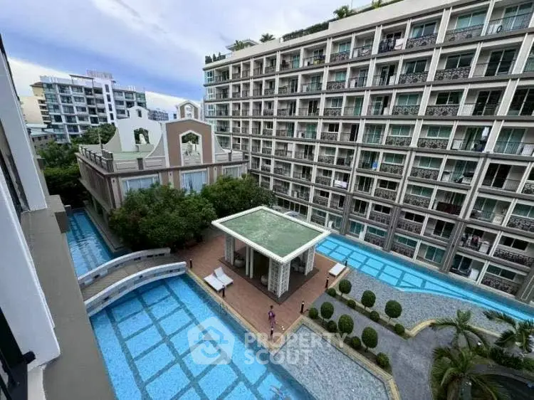 Stunning view of modern apartment complex with pool and landscaped courtyard.