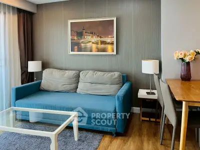 Chic living room with blue sofa, elegant decor, and modern dining area in a stylish apartment.