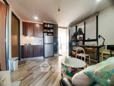 Modern studio apartment with open kitchen and cozy living area, featuring stylish wooden flooring and ample natural light.