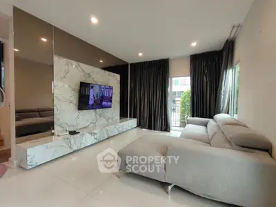 Luxurious modern living room with marble accents and plush gray sofa, perfect for relaxation and entertainment.