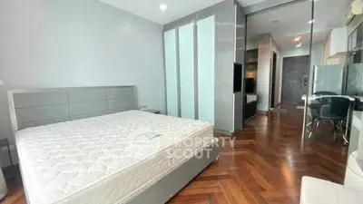 Modern bedroom with sleek design and hardwood floors in a stylish apartment.