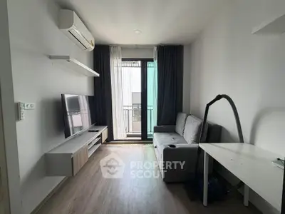 Modern living room with balcony access, featuring sleek furniture and natural light.