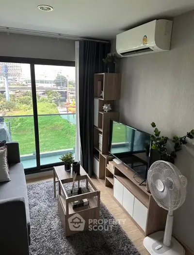 Modern living room with garden view, featuring sleek furniture and air conditioning in a cozy apartment.