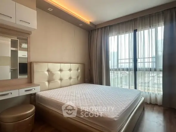 Luxurious bedroom with elegant decor and large window offering natural light.