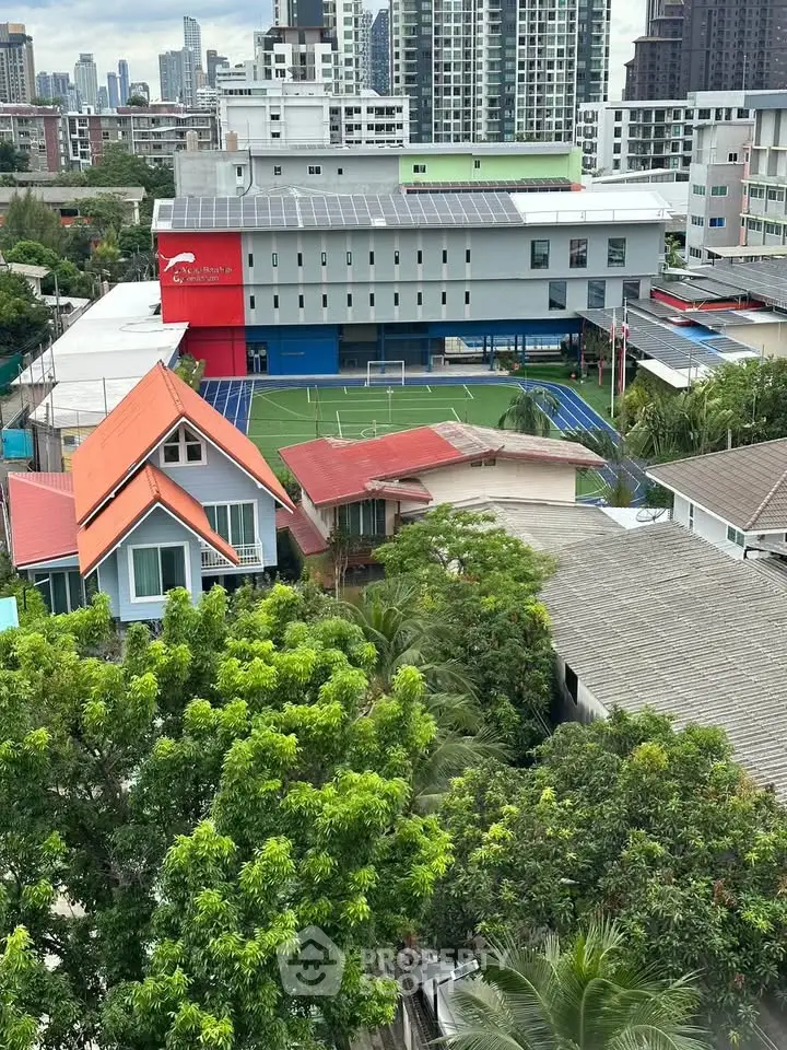 Aerial view of urban residential area with lush greenery and modern buildings.