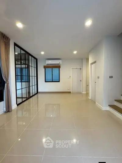 Spacious modern living room with sleek tile flooring and large windows