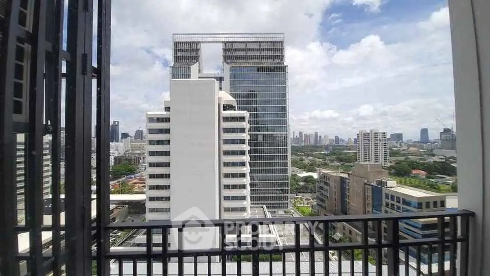 Stunning cityscape view from a high-rise balcony overlooking modern skyscrapers and lush greenery.