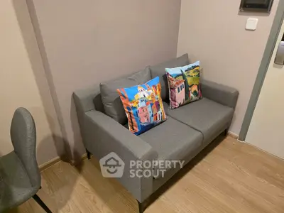 Cozy living room with modern gray sofa and colorful cushions, perfect for relaxation.