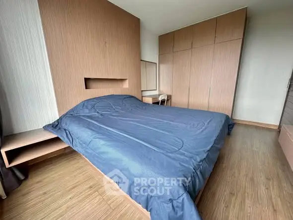 Spacious bedroom with modern wooden furniture and cozy bedding