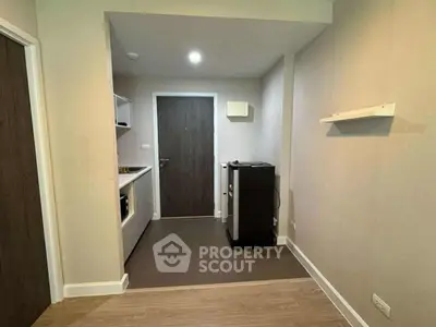 Modern apartment entrance with sleek kitchen and wooden flooring