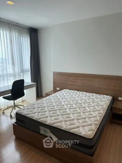 Modern bedroom with large window and comfortable bed in stylish apartment.