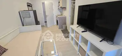 Modern studio apartment with open layout, featuring a cozy living area and compact kitchen.
