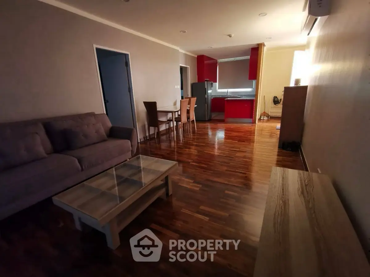 Spacious open-plan living room with modern kitchen and wooden flooring