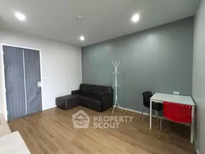 Modern living room with sleek furniture and wooden flooring in a stylish apartment.