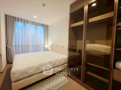 Modern bedroom with large window and stylish wardrobe in a cozy apartment.