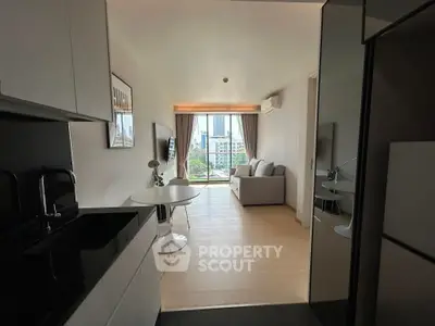 Modern open-plan living room with city view, sleek kitchen, and cozy seating area.