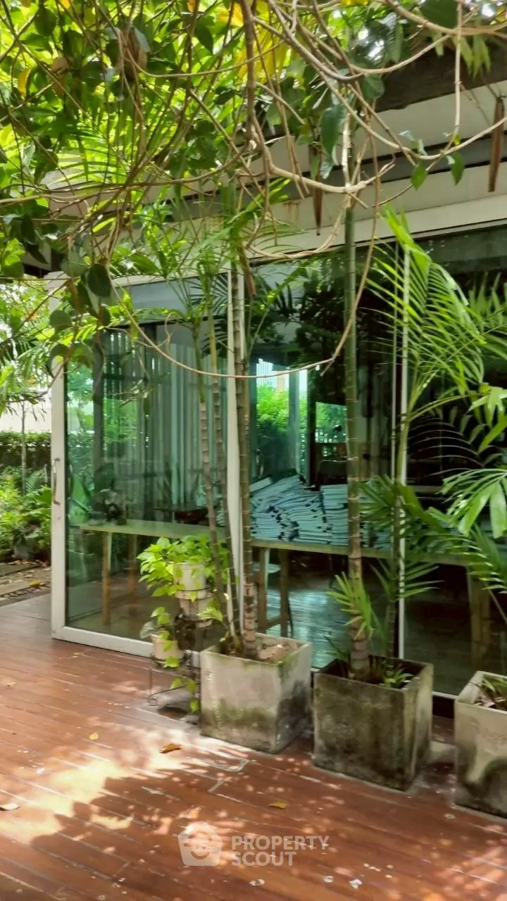 Charming garden view with lush greenery and modern glass doors leading to a cozy interior space.