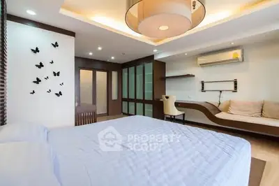 Spacious modern bedroom with stylish decor and ample natural light