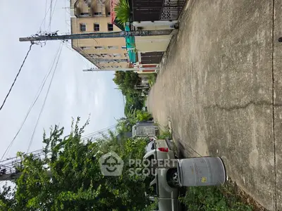 Quiet residential street with parked cars and lush greenery