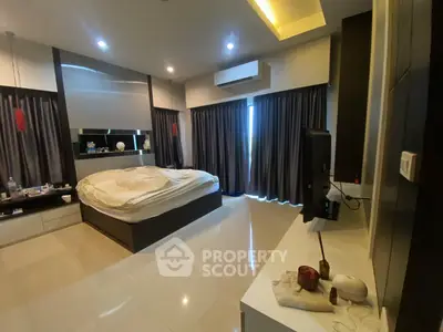 Luxurious bedroom with modern design, featuring a large bed, sleek furnishings, and ambient lighting.
