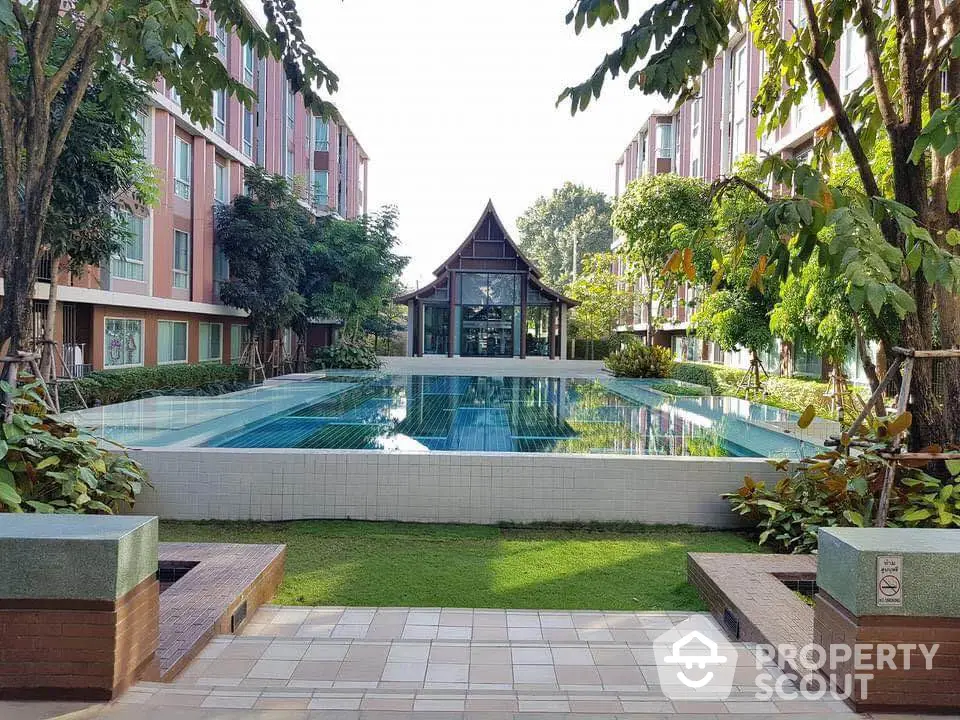 Stunning pool area in modern residential complex with lush greenery and unique architecture.