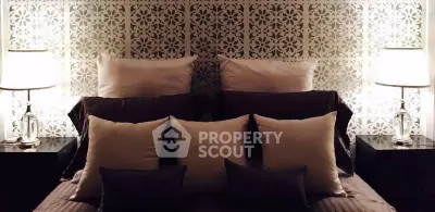 Luxurious bedroom with elegant decor and ambient lighting, featuring plush pillows and stylish bedside lamps.