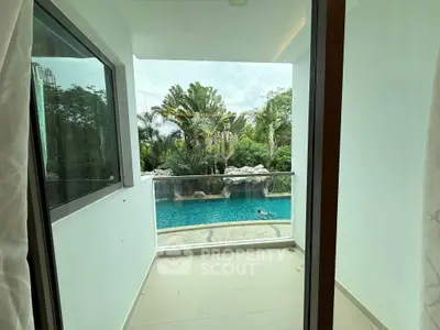 Luxurious balcony view overlooking a serene pool and lush greenery, perfect for relaxation and leisure.