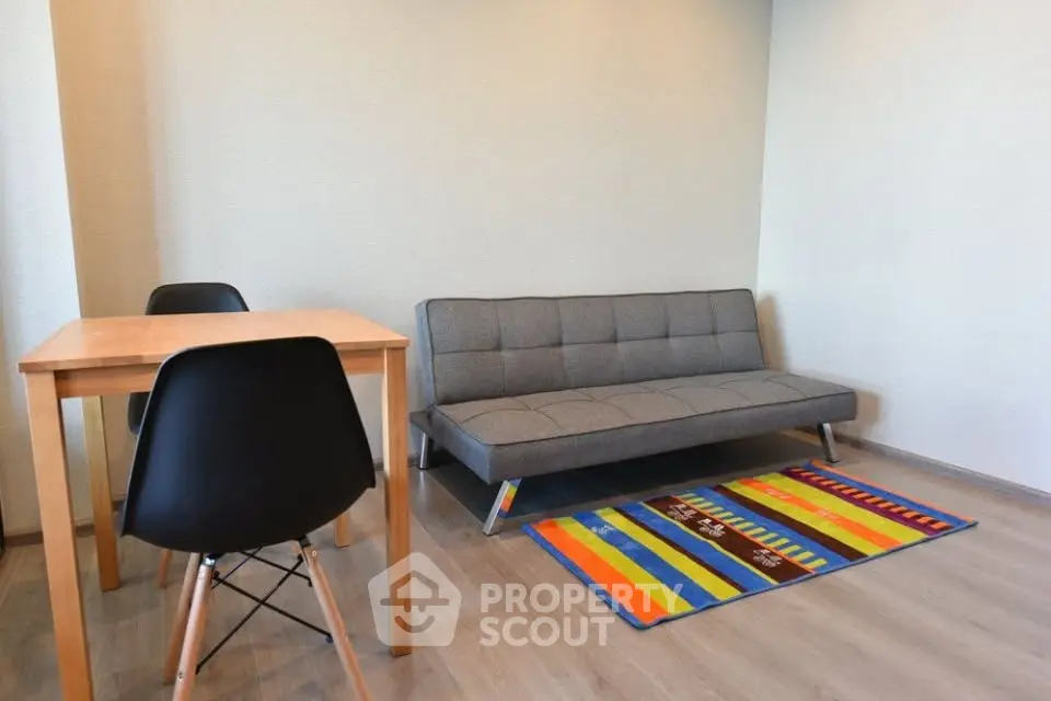 Modern living room with stylish sofa and colorful rug, perfect for cozy gatherings.