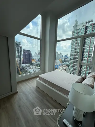 Stunning bedroom with floor-to-ceiling windows offering breathtaking city views in a modern high-rise.