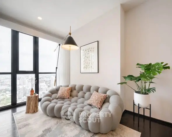 Modern living room with unique sofa and panoramic city view, featuring stylish decor and large windows.