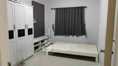 Minimalist bedroom with white wardrobe and bed frame, gray curtains, and tiled floor.
