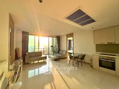 Spacious modern living room with sunset view, open kitchen, and elegant furnishings.