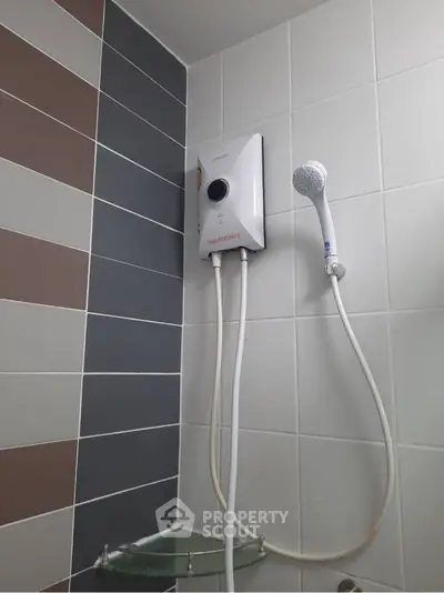Modern bathroom with sleek showerhead and water heater, featuring stylish tile design.
