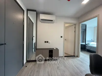 Modern apartment interior with sleek design and air conditioning, featuring a view into a cozy bedroom.