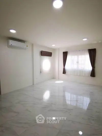 Spacious and bright living room with marble flooring and large windows, perfect for modern living.