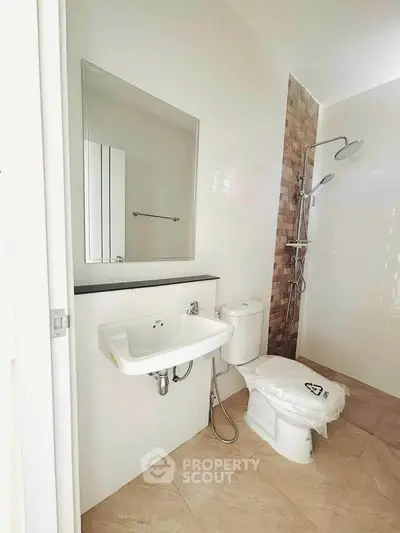 Modern bathroom with sleek fixtures and walk-in shower in a contemporary apartment.