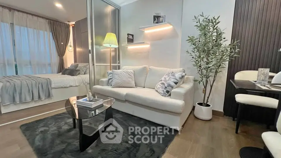 Modern living room with cozy sofa and stylish decor adjacent to a bedroom