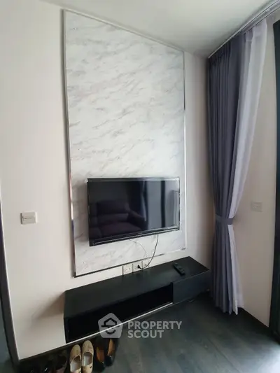 Modern living room with sleek TV setup and elegant curtains